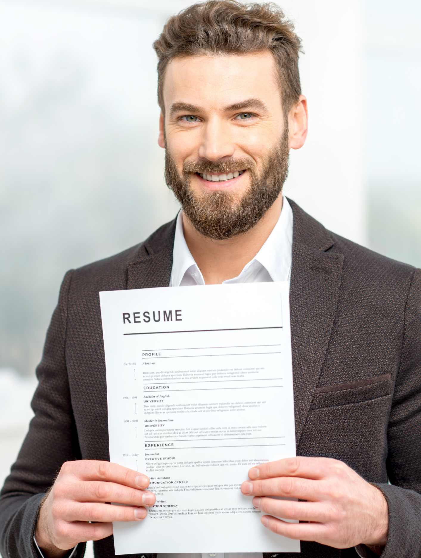 Foto persona con barba, giacca che tiene in mano curriculum vitae